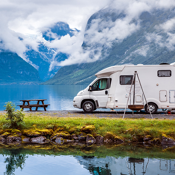 a camper van parked at the foot of some hills